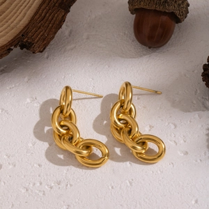 Détail rapproché de boucles d'oreilles pendantes en chaîne d'acier inoxydable dorée