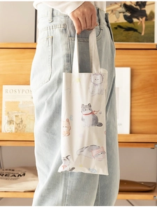 Detail of white canvas tote bag featuring cute hand-drawn cat illustrations for women