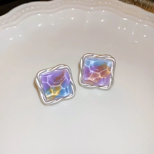 Macro shot of square vintage earrings with purple gradient resin and silver twisted frame