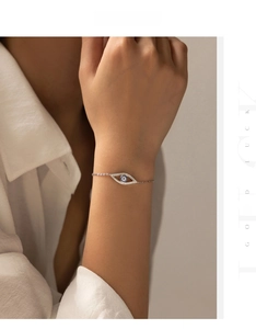 Detail of silver evil eye bracelet with blue and clear crystals on a female wrist