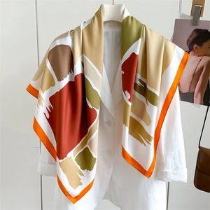 Close-up of abstract patterned silk scarf on a white blazer with vibrant color blocking