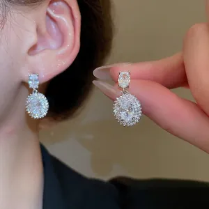 Elegant silver halo earrings with oval cubic zirconia and surrounding crystals on ear