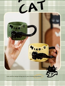 Close-up of olive green and lemon yellow ceramic cat mugs with creative relief handles