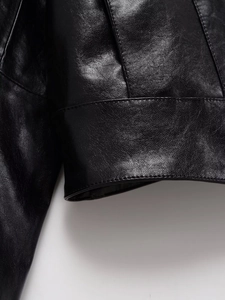 Close-up of black leather jacket texture showing fine grain and professional stitching