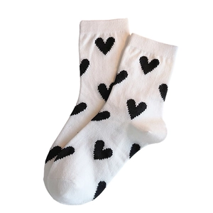 White cotton crew socks for women featuring a minimalist black heart pattern print