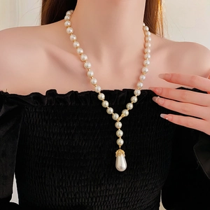 Detail of a vintage pearl necklace with a teardrop pearl pendant on a model neck