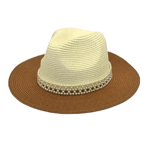 Detail of two-tone woven straw hat with elegant double-row pearl trim on beige crown