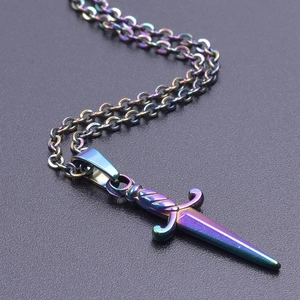 Macro shot of 18k plated rainbow dagger pendant with colorful metallic gradients
