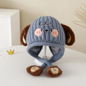 Detail of blue knit hat for kids with plush puppy ears and embroidered cartoon face