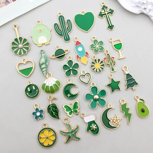 Détail de breloques en émail vert avec cœurs et fleurs pour la création de bijoux DIY