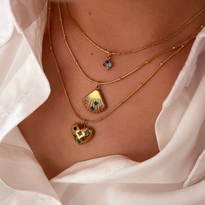 Three-layer gold stainless steel necklace with shell heart and star charms on model