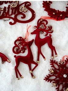 Détails d'ornements renne et flocon bordeaux floqués avec accents de paillettes dorées