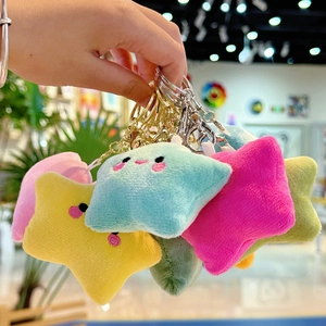 Detail of plush star keychains in macaron colors with cute embroidered faces and metal clasp