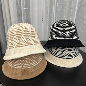 Group shot of colorful geometric knit bucket hats stacked on a table for winter style