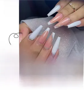 Detail of French tip coffin nails with nude pink base, white edges, and rhinestone accents