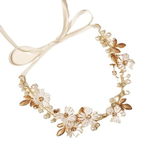 Close-up of handmade bridal headband with white ceramic flowers, pearls and golden leaves