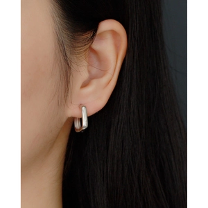 Close-up of minimalist S925 silver U-shaped hoop earring on model with polished finish