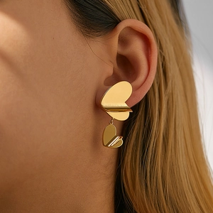 Macro shot of 18K gold plated double layer heart earrings worn on a model's ear