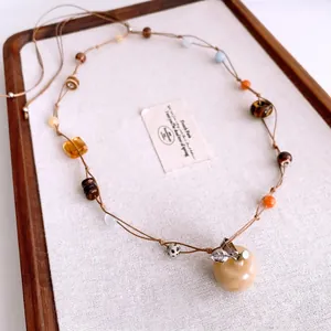 Vintage tiger eye stone beaded necklace with a translucent apple pendant and metal leaf