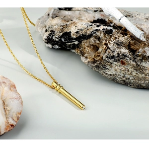Detailed macro of gold bamboo cylinder pendant with sparkling diamond inlay on chain
