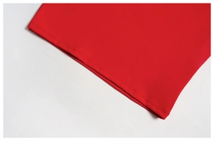 Gros plan de la couture à double aiguille sur le bord d'un vêtement de yoga rouge