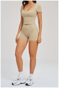 Détail d'un ensemble de yoga beige avec taille haute croisée et tissu extensible mat