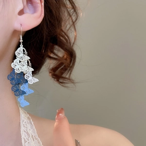 Detail of blue and white hollow butterfly tassel earrings with elegant gradient finish