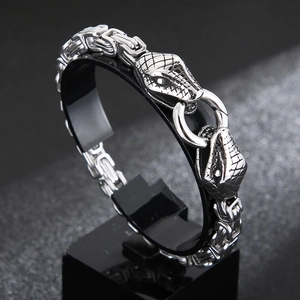 Macro detail of men's stainless steel Byzantine chain with dual snake head clasp