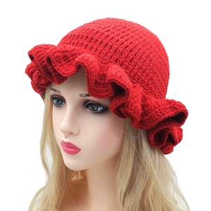 Macro detail of red crochet knit bucket hat showing ruffled brim and wool texture