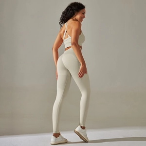 Detail view of seamless backless sports bra and high-waisted yoga pants in cream white