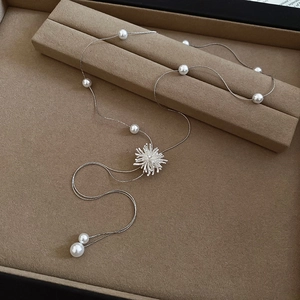 Vue détaillée du collier de perles argenté avec pendentif flocon de neige strass