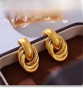 Detailed macro of gold twisted knots earrings with mirror PVD plating in velvet box