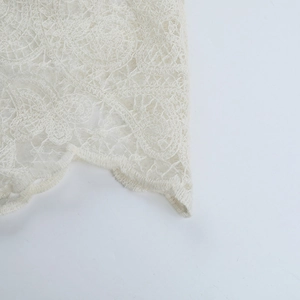 Macro shot of off-white floral lace embroidery and fine knitted hollow details