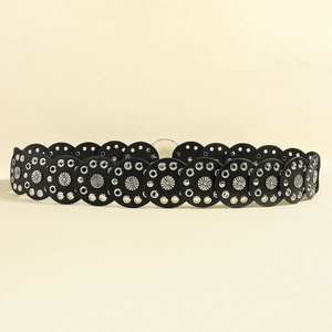 Detail of vintage black leather belt with metal studs and flower motifs in Y2K western style