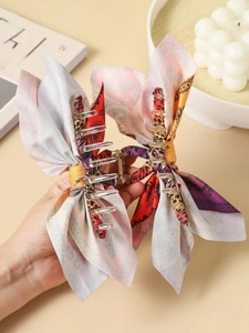 Detail of bohemian claw clip with mixed paisley and leopard print bow accents