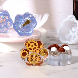 DIY cat paw silicone mold with finished resin pendants on marble background