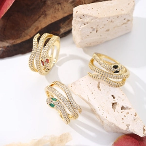 Macro shot of gold-plated brass snake rings with white cubic zirconia and colored gem eyes