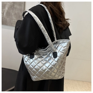 Detail of silver metallic quilted tote bag with diamond pattern and padded wide shoulder strap