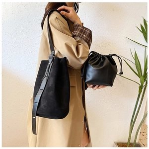 Detail of minimalist black suede tote bag and drawstring bucket pouch set for daily commuting