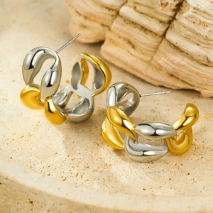 Macro detail of two-tone chain link earrings with polished gold and silver steel finish