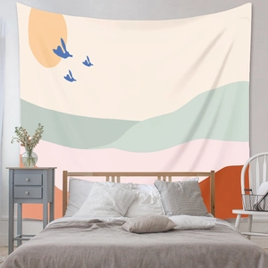 Detail of bohemian tapestry featuring abstract orange sun, blue birds and mountain peaks