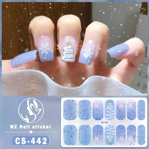Detail of Christmas gel nail wraps with blue gradient, white snowflakes, and tree patterns