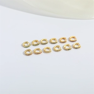 Detailed view of 12 gold mini huggie earrings featuring various colorful zircon stones