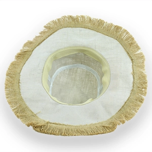 Close-up of the woven linen texture and frayed fringe edges on a wide brim sun hat