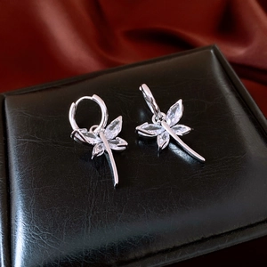 Detailed macro shot of silver butterfly tassel earrings with sparkling zircon stones
