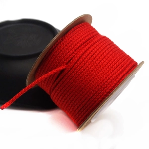Close-up of 1.5mm red cotton cord neatly wound on a kraft paper spool for DIY crafts