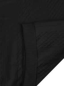 Detailed macro view of black waffle texture knit fabric and ribbed cuff on hoodie
