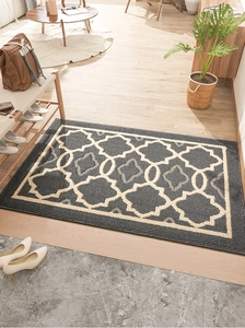 Detalle de alfombra gris con patrón geométrico marroquí en la entrada del hogar