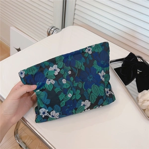Detailed view of blue and green floral jacquard makeup pouch for travel and home storage