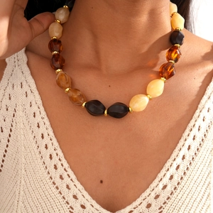 Macro shot of retro acrylic oval beads in black and amber on a long beaded necklace